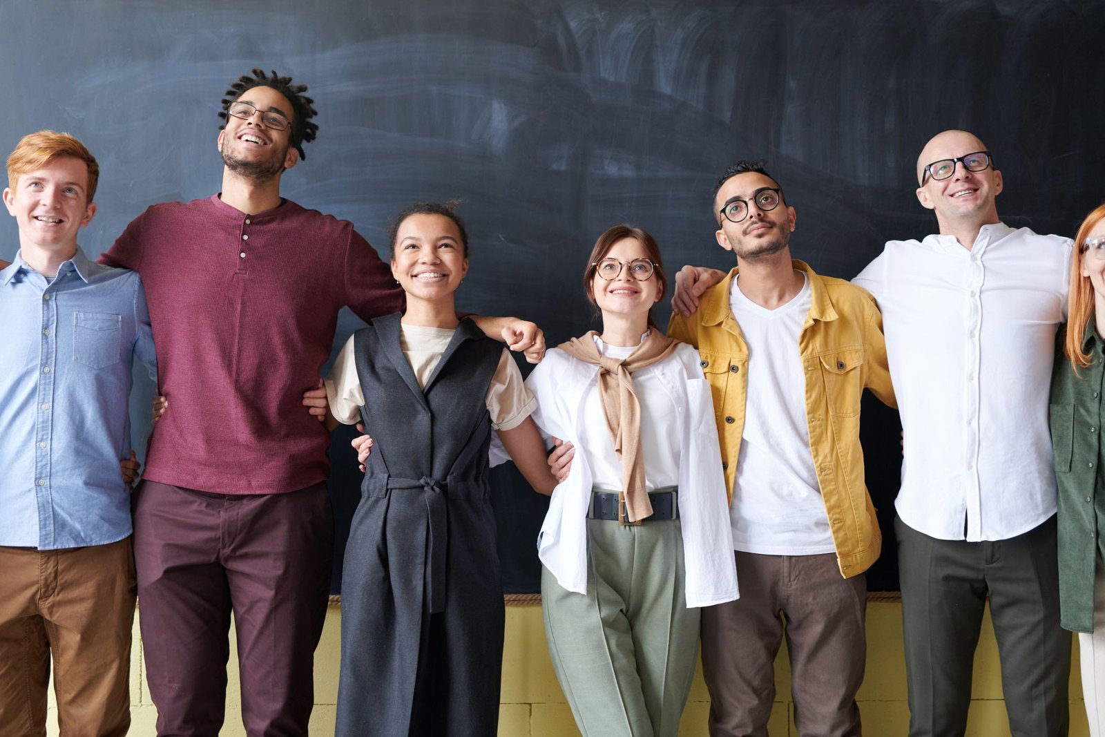A diverse operating team standing together in front of a planning wall